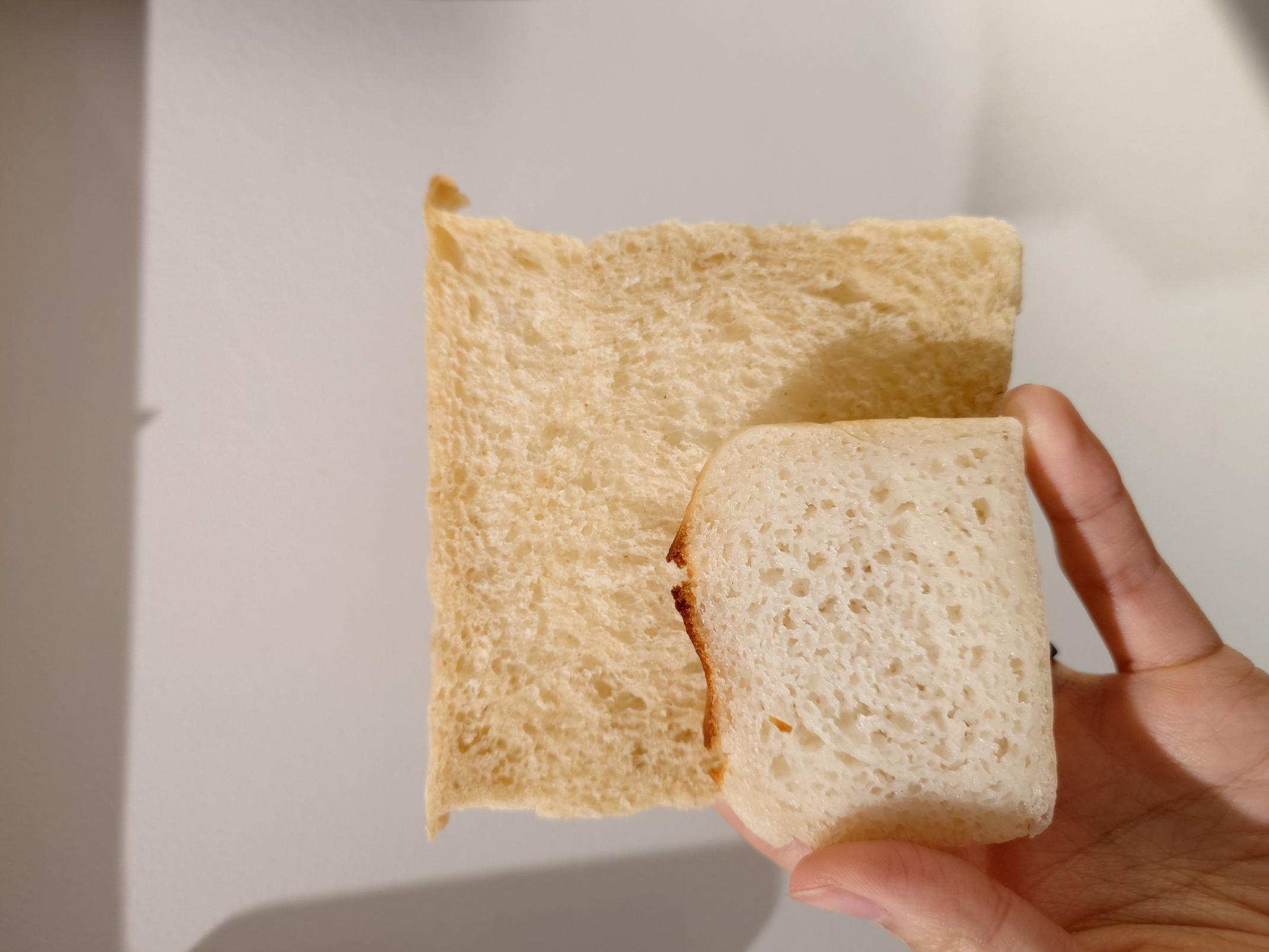 a slice of rice bread on top of a slice of a regular sandwich loaf