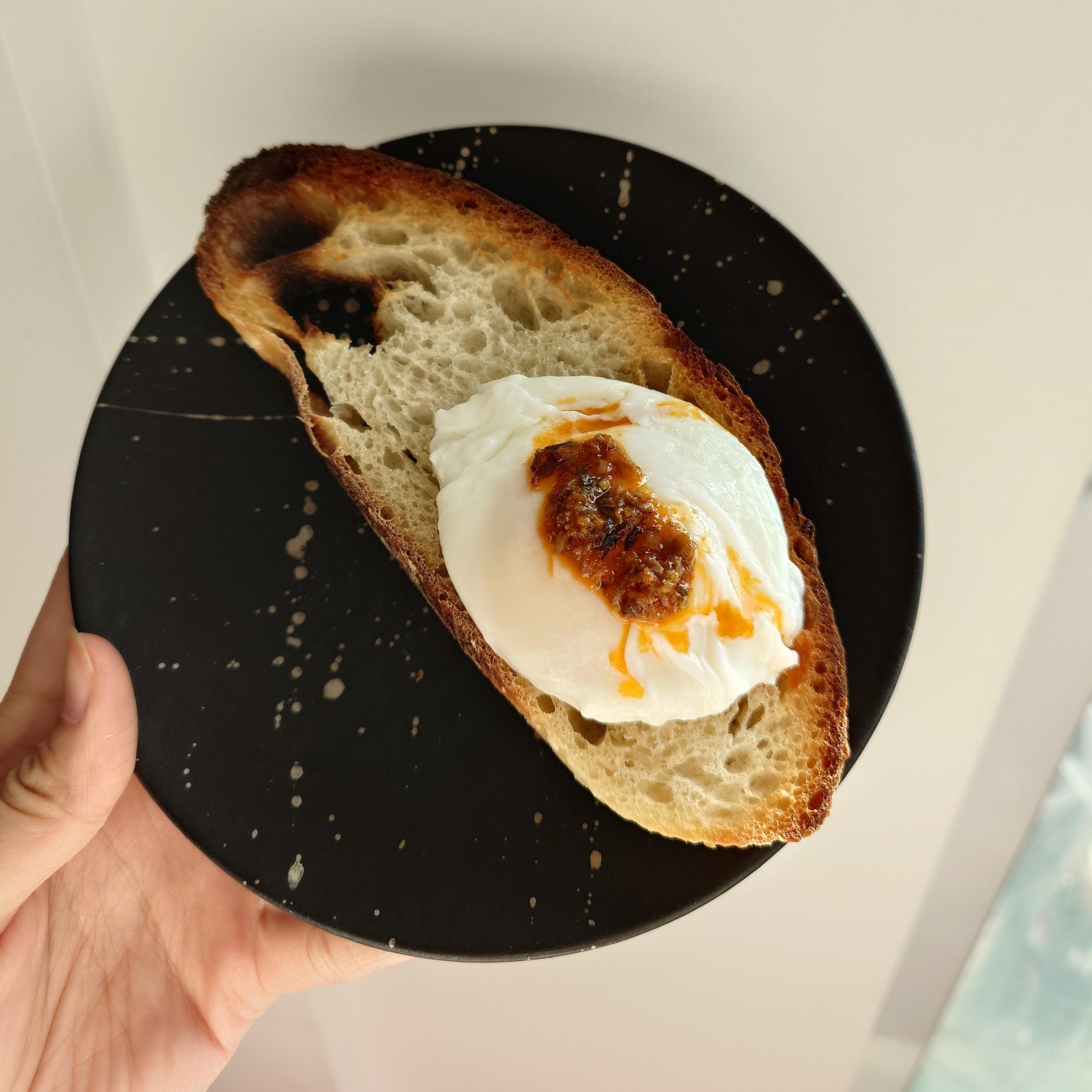 A slice of bread with a poached egg on it, with chilli oil on the egg