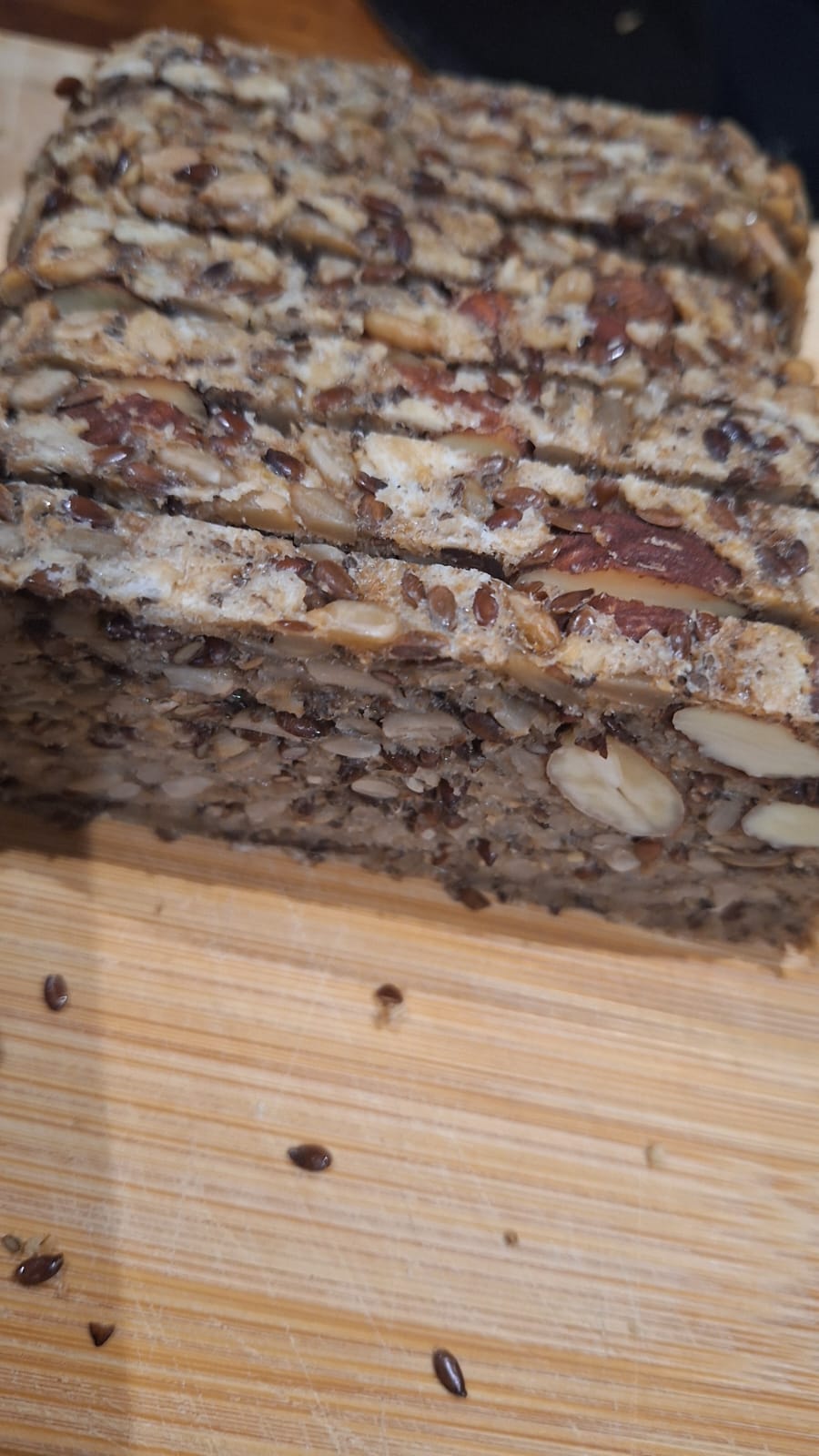 Several slices on a bread board with lin seeds scattered